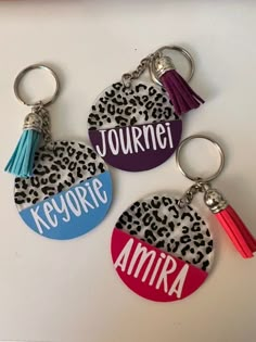 three personalized key chains with leopard print and tassels, one has a name on it