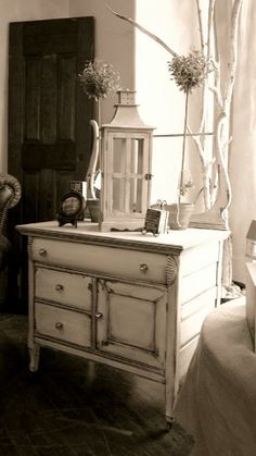 an antique dresser with flowers and candles on top