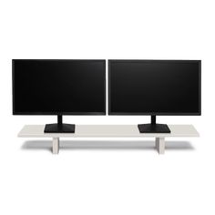 two computer monitors sitting on top of a white table with one monitor facing the other