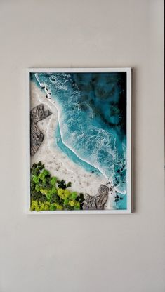 an aerial view of the ocean and beach from above, framed in a white frame