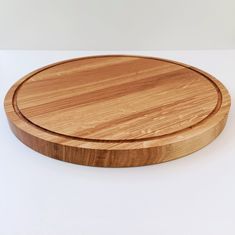 a round wooden cutting board on a white surface with no one around it or in the background