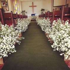 white flowers line the aisle of a church