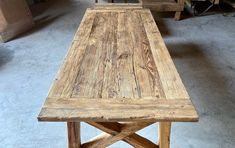 a wooden table sitting on top of a floor next to other tables in a room