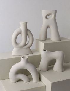 four white vases sitting on top of each other