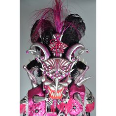 an elaborate mask with pink and black feathers