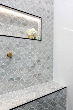 a white toilet sitting under a mirror next to a shower head mounted on a wall