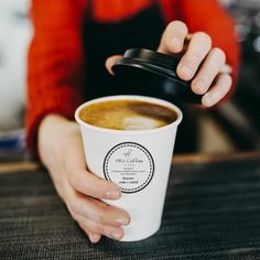 a woman is holding a cup of coffee