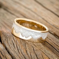 a close up of a wedding ring on a wooden surface