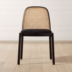 a black and brown chair sitting on top of a hard wood floor next to a white wall