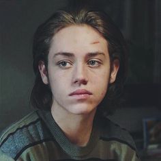 black and white photograph of a woman with long hair looking at the camera while wearing a striped shirt