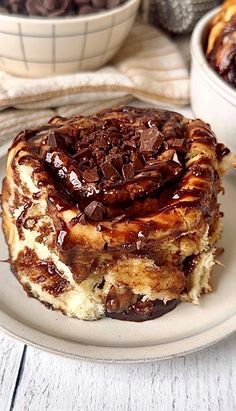 a piece of cake sitting on top of a white plate next to bowls of chocolate chips