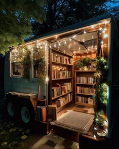 a book truck is lit up with christmas lights and decorated bookshelves in the back