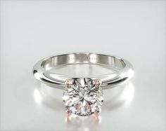 a diamond engagement ring on a white surface