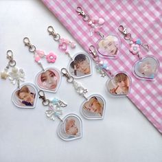 several keychains with pictures of people and flowers on them sitting next to a pink checkered table cloth