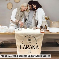 three women are standing behind a table with bottles and glasses on it that says lazzana