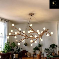 a chandelier made out of branches and balls hanging from the ceiling in a living room