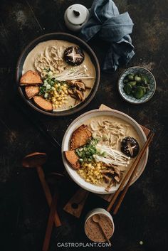 two bowls filled with soup next to chopsticks