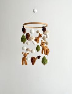 a crocheted mobile with animals hanging from it's sides on a white wall