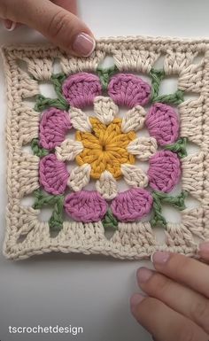 someone is crocheting a square with flowers on it