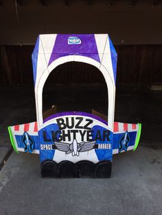 an inflatable buzz lightyear vehicle is parked on the pavement with it's door open