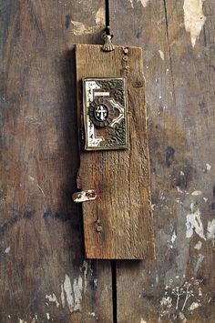 a piece of wood with an old clock on it's side hanging from a chain