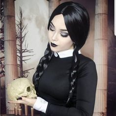 a woman with long black hair holding a skull