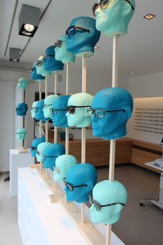 many blue masks are lined up on wooden sticks with eyeglasses attached to them