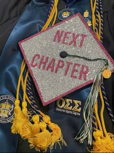 a graduation cap with the words next charter written on it and tassels attached