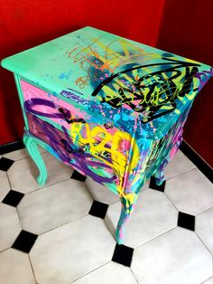 a colorful dresser with graffiti painted on it