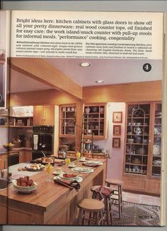 an open book shows a kitchen with wooden cabinets and counter tops, along with dishes on the island