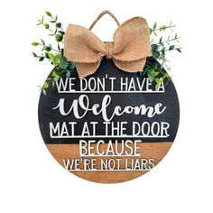 a wooden sign that says we don't have a welcome mat at the door because we