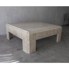 a concrete coffee table sitting on top of a cement floor