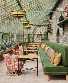 an outdoor seating area with green couches and potted plants