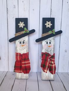 two snowmen with hats and scarfs are standing next to each other