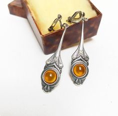 Beautiful 925 silver drop-shaped hanging earrings set with amber. Pendant length, without leverbacks: approx. 4.3 cm,  Amber cabochon diameter approximately: 0.8 cm The earrings are each hallmarked "925". Vintage condition, with signs of wear,  The leverbacks can be a little out of shape. The silver appears matted. A rhinestone appears "blind". This may have been replaced at some point. Art Nouveau Earrings, Art Nouveau Earring, Amber Pendant, Hanging Earrings, Art Deco Jewelry, 925 Sterling Silver Earrings, Antique Art, Jewelry Art, Sterling Silver Earrings