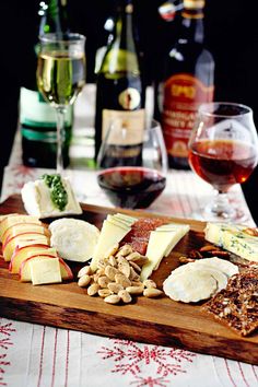 a wine glass and some cheese on a wooden platter with other wines in the background