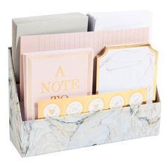 a marble desk organizer with note cards and envelopes