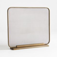 a white and gold framed object on a wooden base with a metal stand in the middle