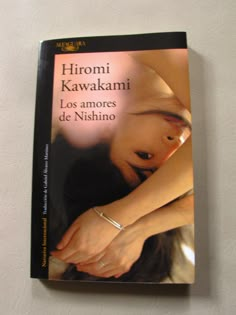 a book with a woman's hand on top of her head and the words, hiromi kawakami los amores de nishino