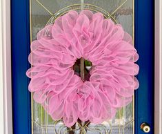 a pink mesh wreath on a blue front door