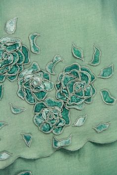 green fabric with flowers and leaves on it