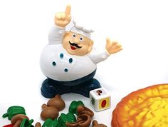 a chef figurine sitting on top of a table next to other toy items