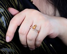 a close up of a person wearing a ring on their finger and holding something in her hand