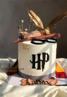 a cake decorated with feathers, stars and an open book is on top of a table