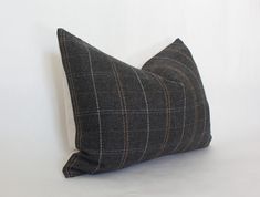 a black and white pillow on a white background with a brown checkerboard pattern