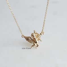 "Throwback to our cult favorite, or just because we love Baby Angels! I remember having Baby Cupids all over my folders in the 90s. Add a touch of minimalist elegance to your jewelry collection with our 18K Gold Dipped Cupid Arrow Angel Necklace. The pendant features detailed texture of the sings along with realistic bow and arrow. The 18K gold plating adds a luxurious touch, while the adjustable chain ensures a perfect fit for any neckline. This versatile necklace is perfect for everyday wear o Cupid Arrow, Alphabet Jewelry, Cupids Arrow, Y2k Jewelry, Angel Necklace, Jewelry Bridesmaid, Bow Jewelry, Etsy Bridesmaid Gifts, Gold Dipped