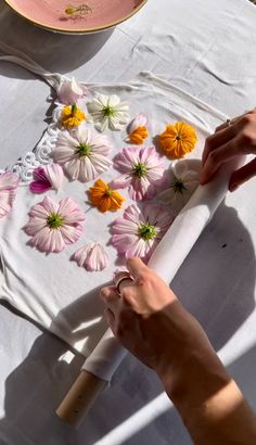 a person cutting paper with flowers on it