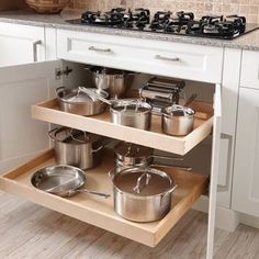 an open cabinet with pots and pans on it