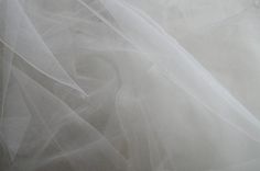 the fabric is white and has many layers of tulle on it's surface