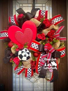 the wreath is decorated with red roses and black and white checkered ribbon, heart shaped